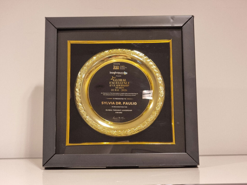 Eine gold verzierte Auszeichnung für Sylvia Dr. Paulig mit schwarzem Hintergrund und eleganter Rahmung